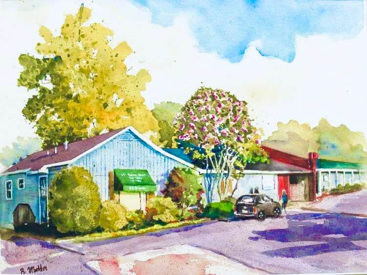 Watercolor painting of a small motel with a blue building, green awning, parked car, and trees. A person walks near the parking lot close to the Womans Exchange storefront.