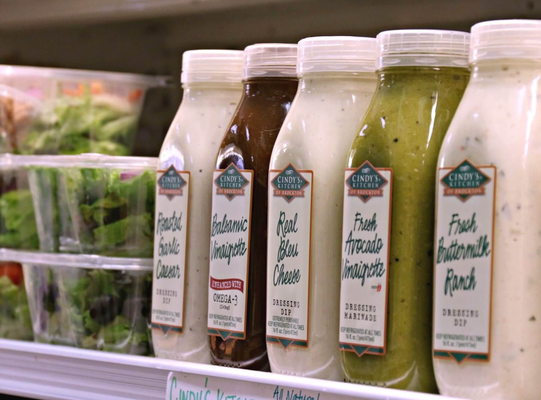 Juices and salads on a shelf at The Produce Place in Sylvan Park.