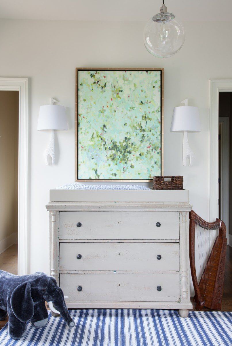 A pair of giraffe sconces hang above a repurposed chest turned changing table with the addition of a simple top. The gorgeous painting is by Erin McIntosh, and I can promise it looks just as pretty at 3am. 
