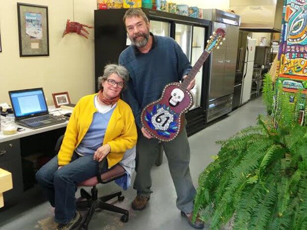 Kathy and her husband Bob, who is holding a guitar custom-made by