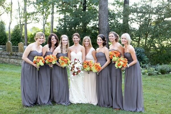 Caption:  By selecting a neutral palette of color for the bridesmaid dresses, their bouquets offer a gorgeous burst of color.   The bouquets, created by the Tulip Tree, are made of roses, hydrangeas, dahlias, and hypericum berries.  What a wonderful idea to have the maid of honor, the bride's sister, wear a gown that complimented the wedding dress. 