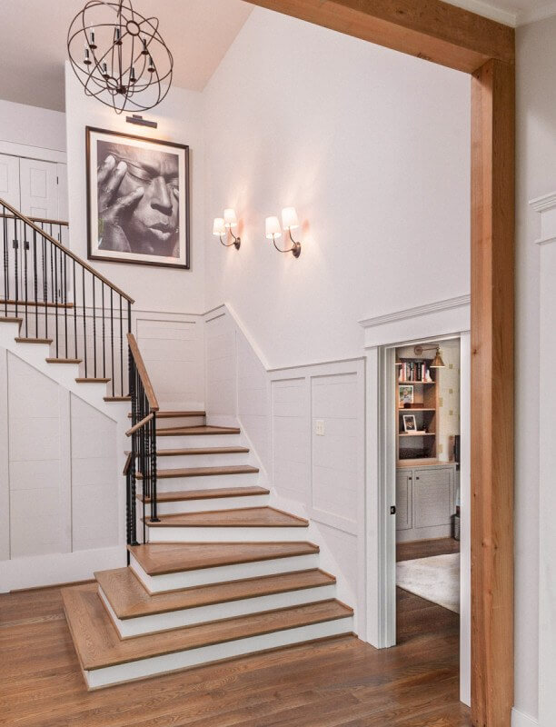 The home entrance opens onto a spacious foyer with a grand staircase. Christopher Architecture and Interiors
