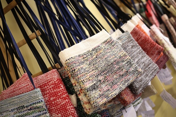 Crossbody and messenger bags hang ready for transport from The Weavehouse to a retail location.