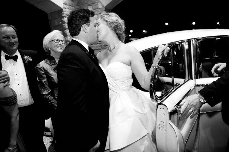 Bride and Groom Kissing in front of antique car