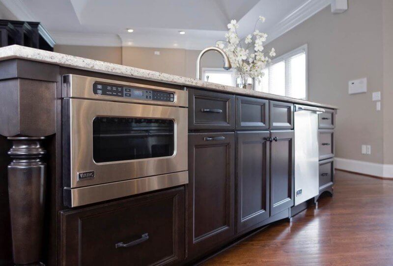 Installing an ice machine and microwave beneath the island minimizes their visibility.