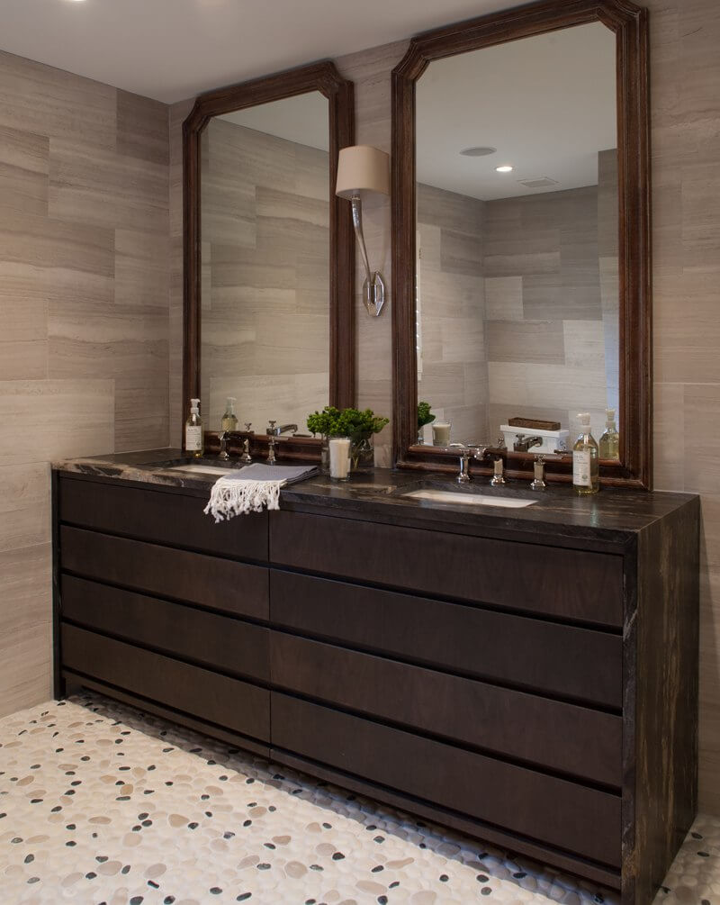 In the master bath, leathered black granite countertops and pebbled stone flooring are textural, refined and masculine. | Image credit: Julie Wage Ross