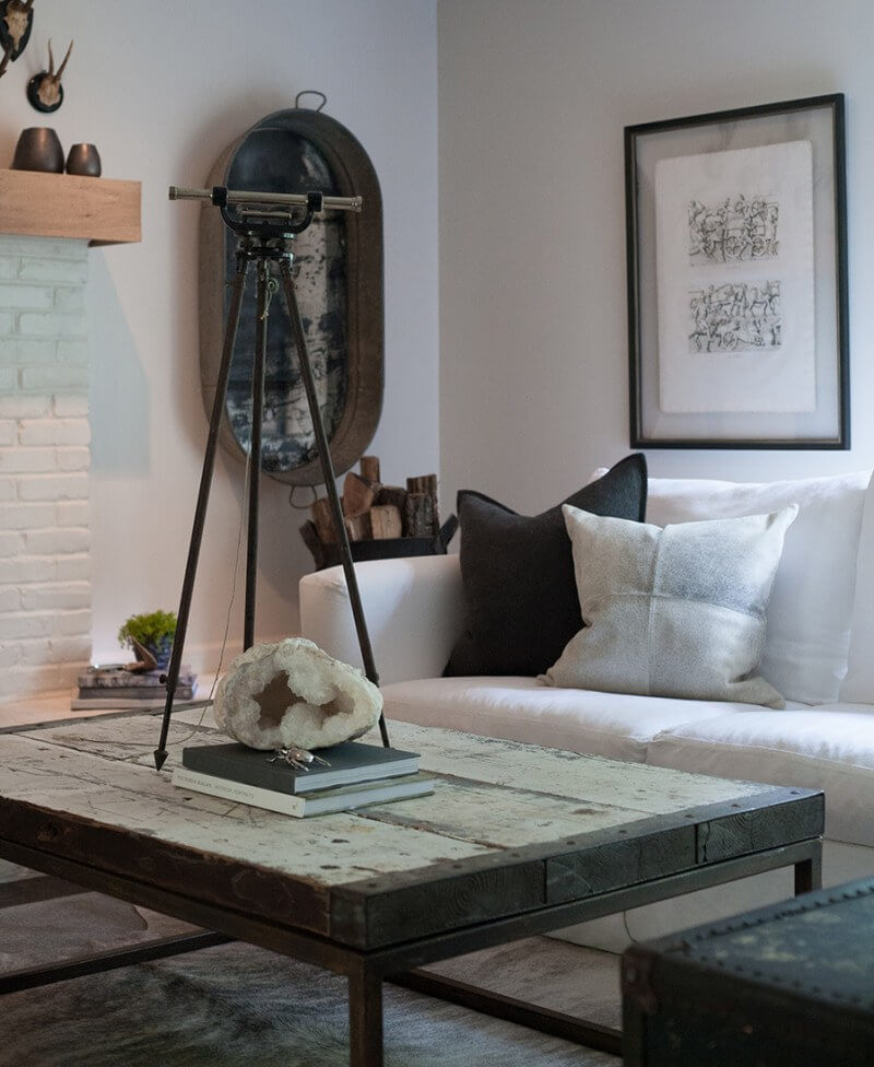Chris Garner of Garner Picture Framing helped Sean with the antiquing of repurposed washtub mirros that now flank his fireplace. The coffee table is another old object with new life, a trap door turned into a charming centerpiece for this sitting area.