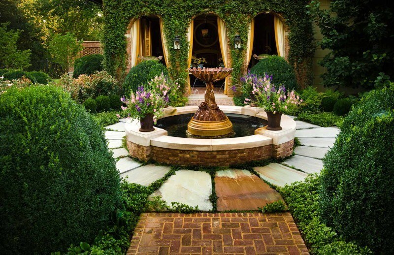 this lush courtyard is the perfect balance between masonry and green space. Part of 8 garden fountains featured in this article by StyleBlueprint