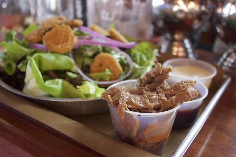 Feast BBQ: BBQ Salad with Pulled Pork, Fried Pickles, Red Onion, BBQ sauce, green onions and smoked mustard dressing.