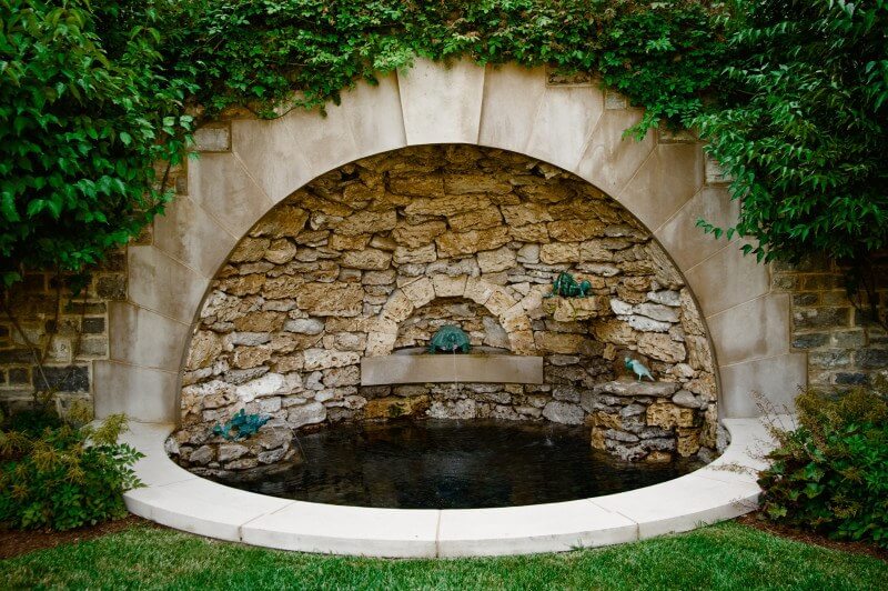 This rustic stone fountain by Page|Duke is the perfect platform for dramatic lighting. Part of 8 garden fountains featured in this article by StyleBlueprint