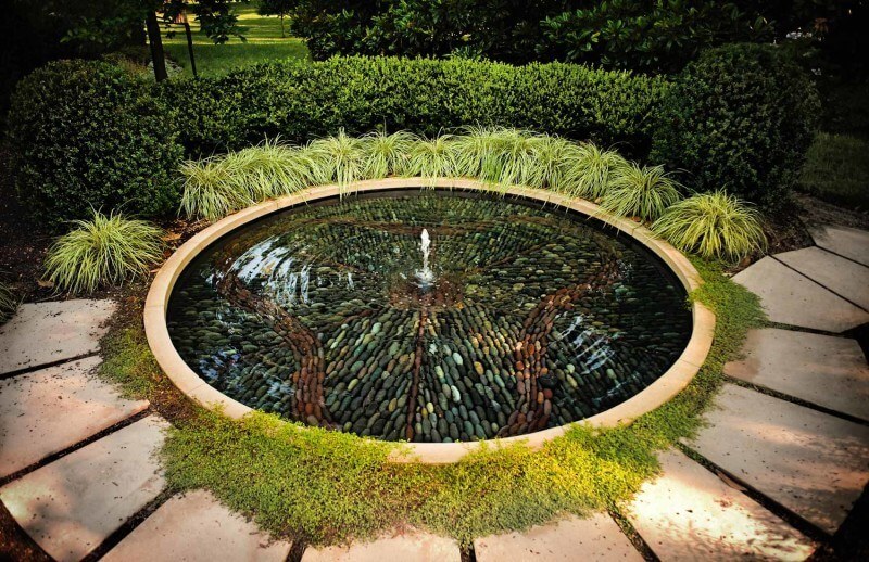 The bottom is lined with and intricate stone which reflect beautiful earth tones through the surface of the water. Part of 9 garden fountains featured in this article by StyleBlueprint