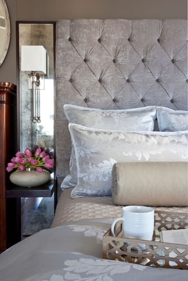 Mirrored sconces add a reflective quality to the master bedroom.