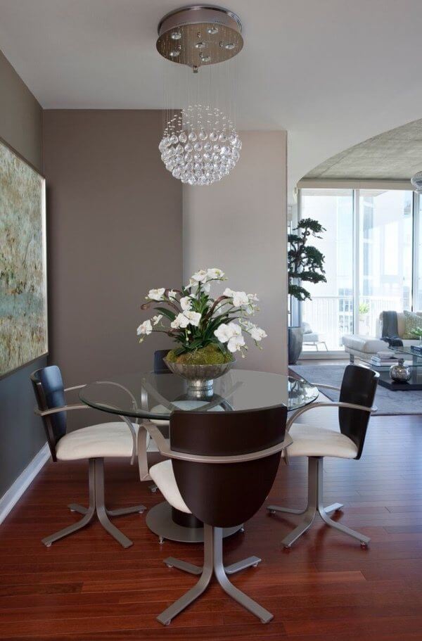 “We painted dining room with “A Dash of Pepper” paint from Benjamin Moore, and it made the space more intimate and cozy,” says Hardy. “You shouldn’t be afraid to paint a small area in a dark color.” An artsy chandelier illuminates an abstract painting by artist Blakey Berring, who is out of Texas.