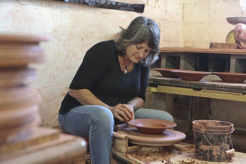 Leeds, AL: Earthborn Pottery, created and owned by Tena Payne, sells hand-made pottery to restaurants across the south, as well as to individuals. Several stores in Birmingham offer it in their bridal registry. Signature icon is the fossil or annonite (?) shell, stamped in all pieces. Earthborn hit the big-time when Chris Hastings, chef/owner of Hot and Hot Fish Club, used the pottery line when serving his winning dishes on the Food Channel's BBQ Throw Down vs. Bobby Flay.