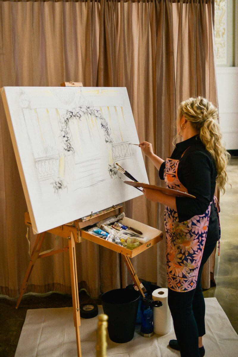 Live event painter Allison Webb began with the floral wedding arch and elegant columns of The Cadre Building.