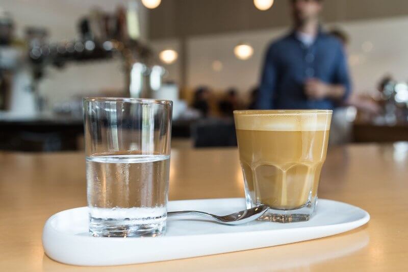A foamy latte is served with a club soda at Steadfast Coffee.