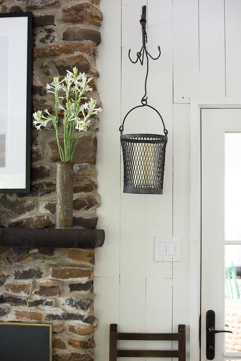 Beside the fireplace, there is a basket for easy storage of miscellany and plenty of hooks above for hanging clothes.