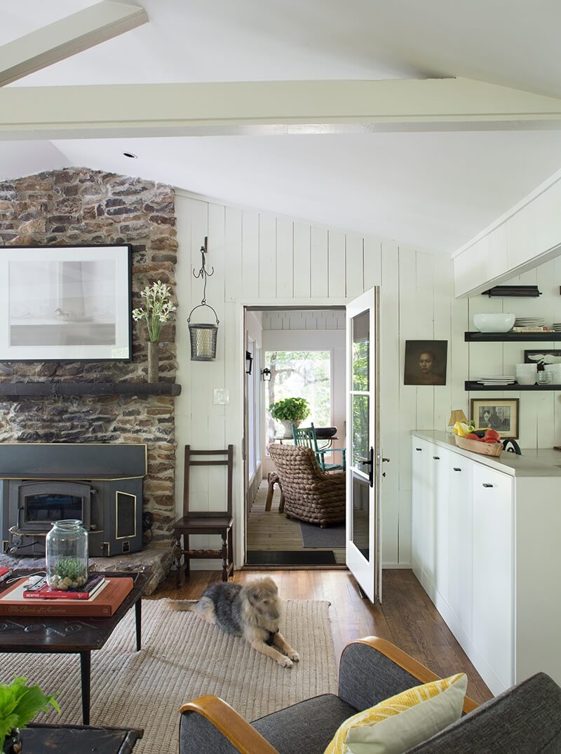 The great room’s vaulted ceiling adds volume to the small cabin. Above the mantel, a photograph by Ian Lemmonds takes center stage.