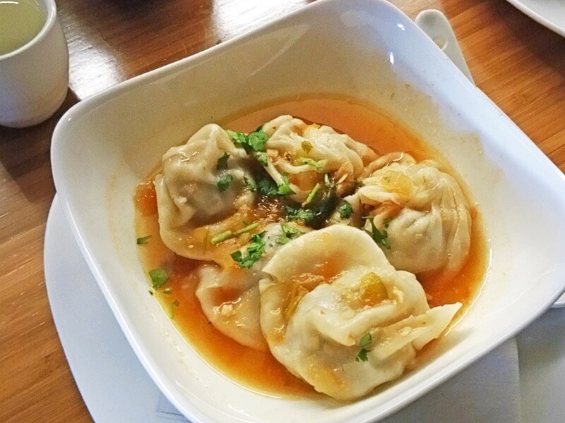 The wildly popular Momos, steamed Nepalese dumplings in a savory broth with Alabama tomato vinaigrette, are a must-try item at Bamboo on 2nd.