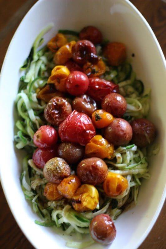 Zucchini noodles with roasted tomatoes in white bowl