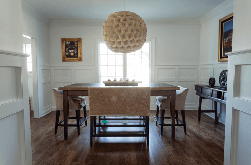 A large hanging light, like this striking piece of art, can bring texture and dimension to areas like the dining room.