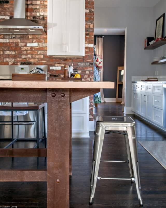 This kitchen blends brick, painted and stained woods and metals to create an industrial but warm interior.