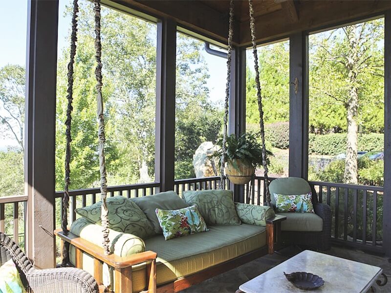 Surrounded in greenery, like a grown-up treehouse, this screened-in haven is where the homeowner loves to spend most of her time in the home.