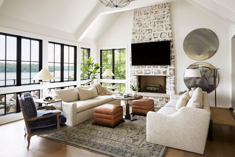 A living room with large windows and a fireplace.