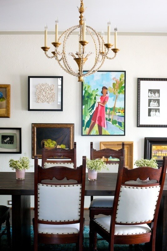 The gallery wall featured in the dining lends interest and personality to the space. Mixed styles of art and various frames echo the pattern play through textiles in the living room and foyer.