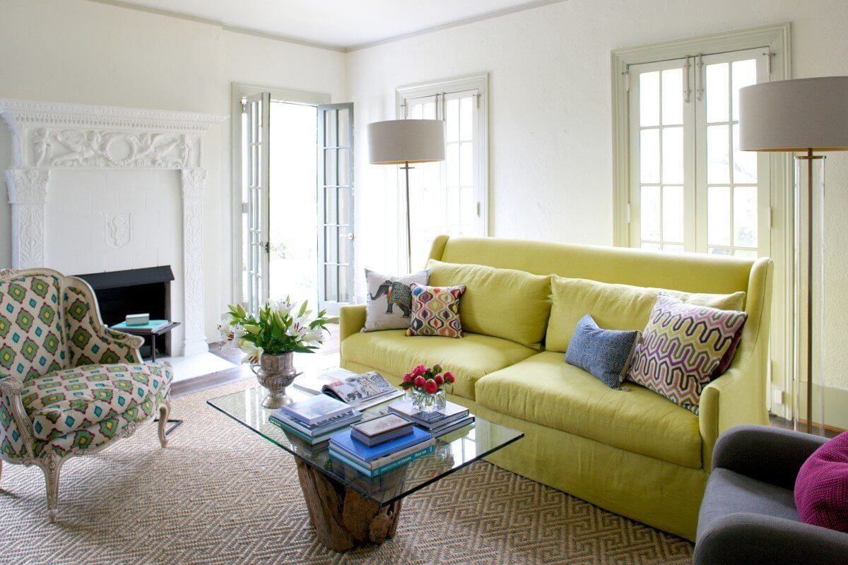 This high back citron-green linen sofa anchors the space and various patterns and textiles throughout the room give a nod to one of the homeowner’s background in retail fashion.