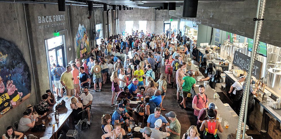 Birmingham residents and vistors alike love spending their days at Back Forty Beer Company. Image: Back Forty Beer Company Crowd of people in Back Forty Brewing Co, a Birmingham craft brewery