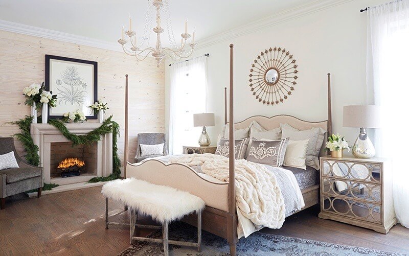 Rich texture is key in crafting an elegant bedroom, and this fine master suite is no exception. Luxurious bedding, satin pillows, a faux-fur stool and rich gray velvet chairs all contribute to the sumptuous feel of the space. The feminine four-poster bed plays against more masculine touches, like the washed wood walls and dark hardwood floor, creating a well-rounded and relaxing room.