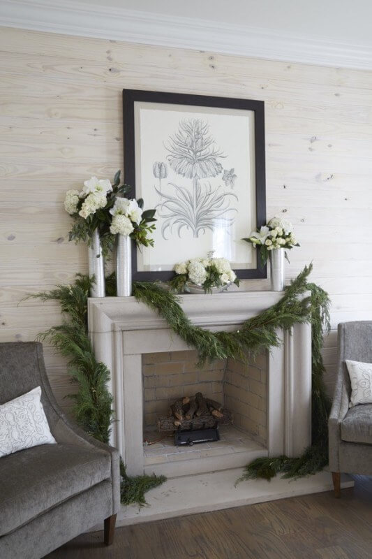 The asymmetry of this casually draped fresh garland coupled with the classic elegance of the mantel's strong architectural lines results in a striking and inviting fireside bedroom seating area.