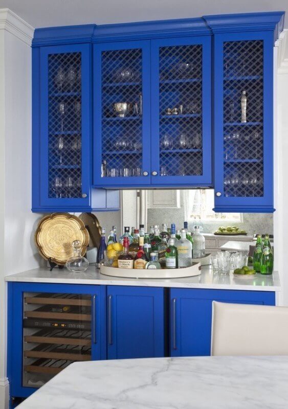 Royal blue lacquered cabinets in the butlers pantry are given a custom touch with brass metal grates on upper cabinet doors.