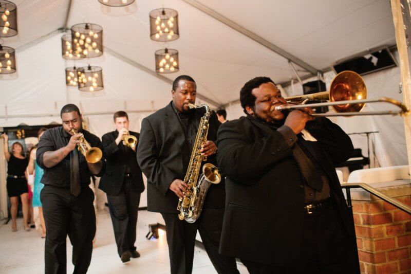 The band leads guests from the reception.