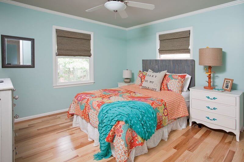 This lake home with blue walls and orange accents and a brown ceiling is so happy! Interior designer: Beth Johnson