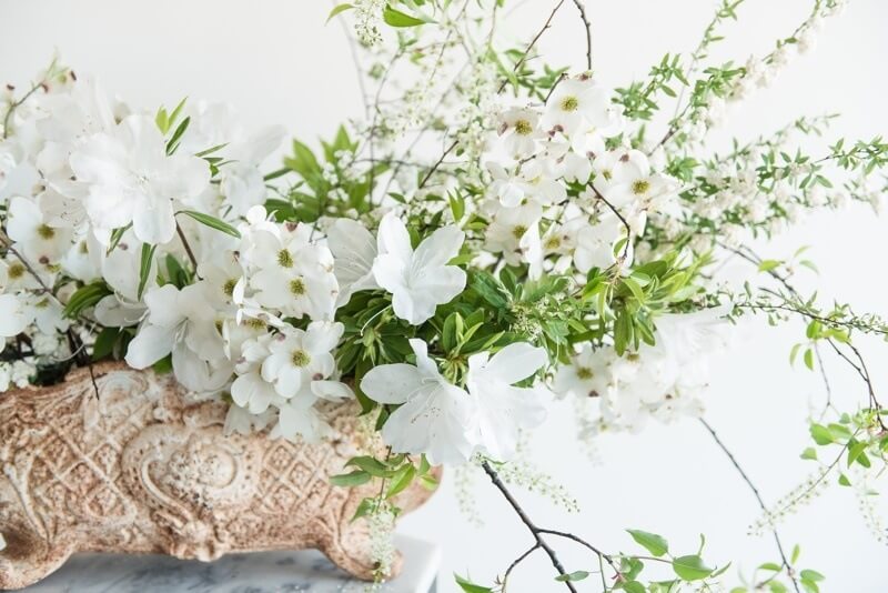 This spring white-and-green arrangement is stunning, its delicate flowered branches reaching out in long graceful arches like brush strokes. This spring white-and-green arrangement is stunning, its delicate flowered branches reaching out in long graceful arches like brush strokes.