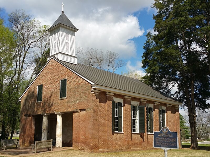 The Mooresville brick church was built in the Greek Revival period with bricks that were unusually symmetrical for handmade bricks, and the steeple features a large wooden hand pointing toward heaven. 