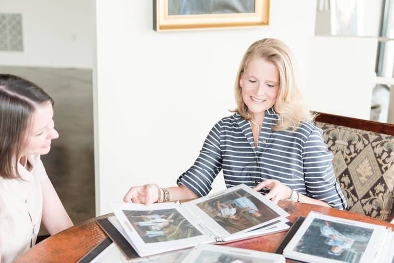 Kelly shows a client samples from their extensive library of over 150 portrait artists' works.