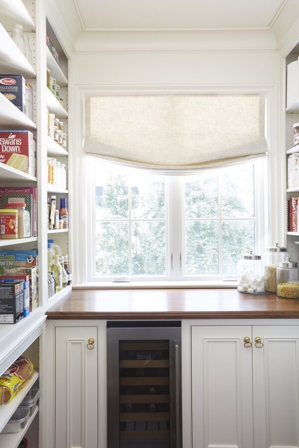 Adjacent to the kitchen, the walk-in pantry houses all the food not often needed in the kitchen and a small 15-inch wine storage SubZero for convenience to the dining room. The custom cabinetry matches the kitchen and features a walnut countertop with a lot of adjustable shelves for seamless organization. Adjacent to the kitchen, the walk-in pantry houses all the food not often needed in the kitchen and a small 15-inch wine storage SubZero for convenience to the dining room. The custom cabinetry matches the kitchen and features a walnut countertop with a lot of adjustable shelves for seamless organization.