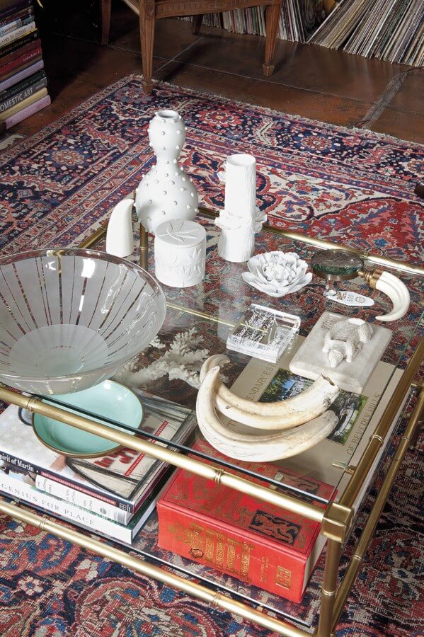 "This coffee table composition includes a Lucite box filled with dirt from Graceland, Kenyan boar tusks, modern porcelain pieces, including one by Jonathan Adler, a 1970s edition of Debrett’s peerage," explains Susan.