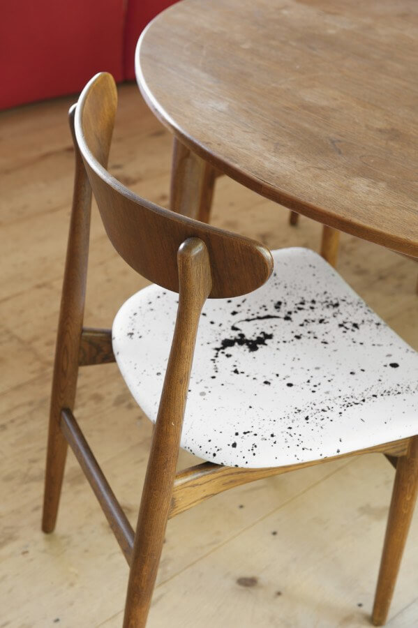 Interior designer Fawn Galli added a twist to this piece of Danish mid-century modern “brown furniture” with a Jackson Pollock-esque smattering of black paint on white hide for the chair’s upholstery.