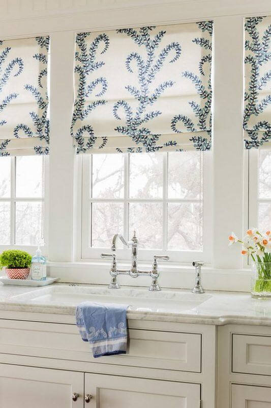 Window treatments in a kitchen add pattern and shade. 