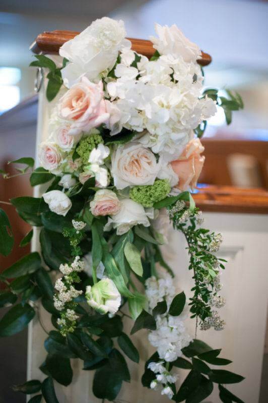 Tight woven floral wreaths adorned the entrance to the sanctuary and sprays lined the isles and served as a backdrop for the altar.