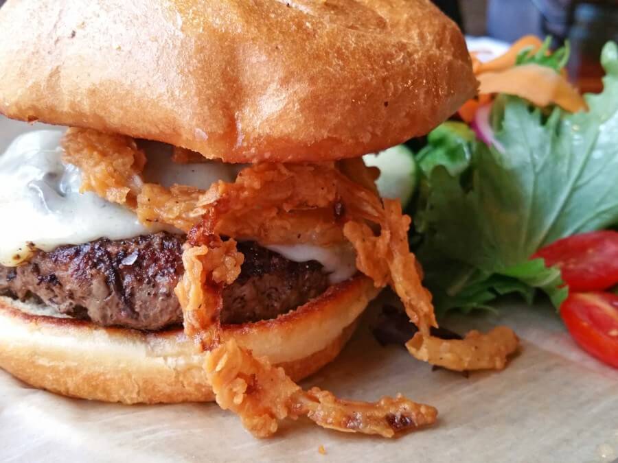 The Hound's bison burger with sautéed mushrooms, Swiss cheese, and fried tobacco onions is one of the most popular menu items. The Hound's bison burger with sautéed mushrooms, Swiss cheese, and fried tobacco onions is one of the most popular menu items.