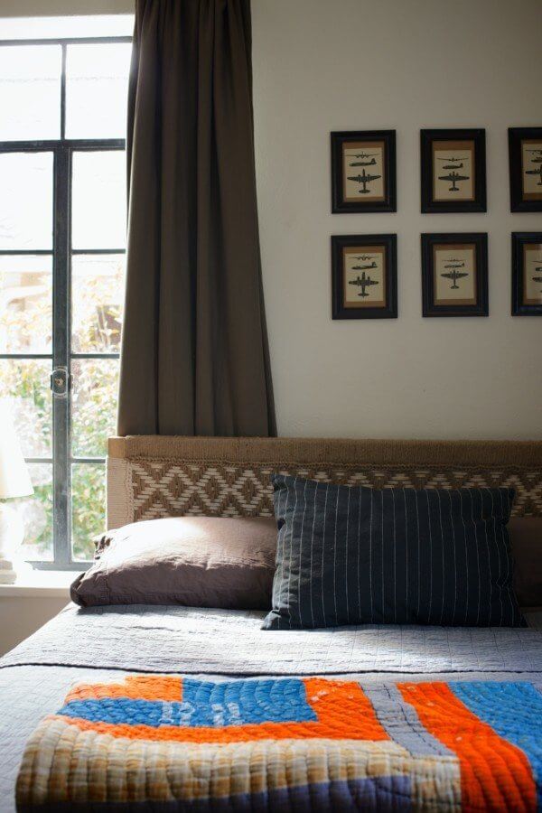 The woven headboard was actually a HomeGoods find, and the framed airplane prints are vintage flash cards for soldiers to learn planes.
