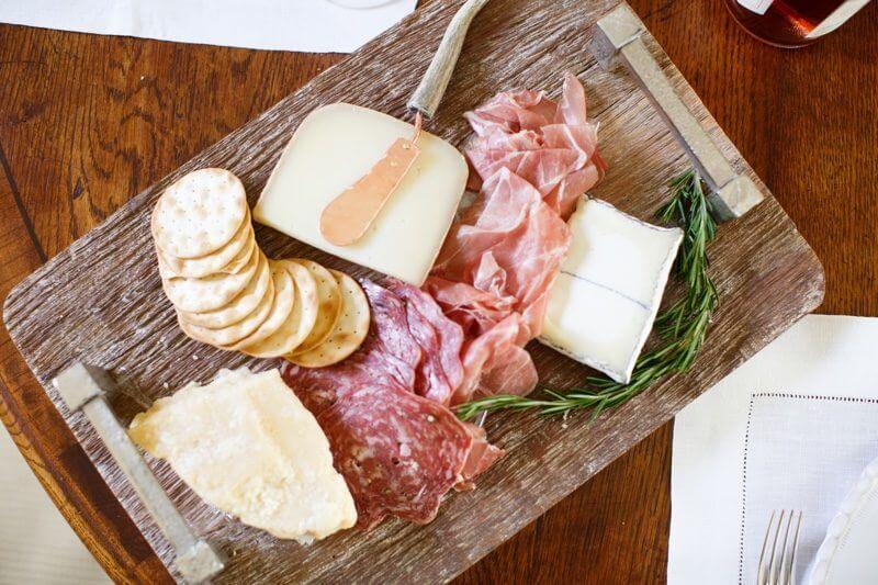 A beautifully arranged charcuterie board with blush prosciutto, soppressata and a mix of hard and soft white-toned nutty cheeses is as beautiful as it is delicious.