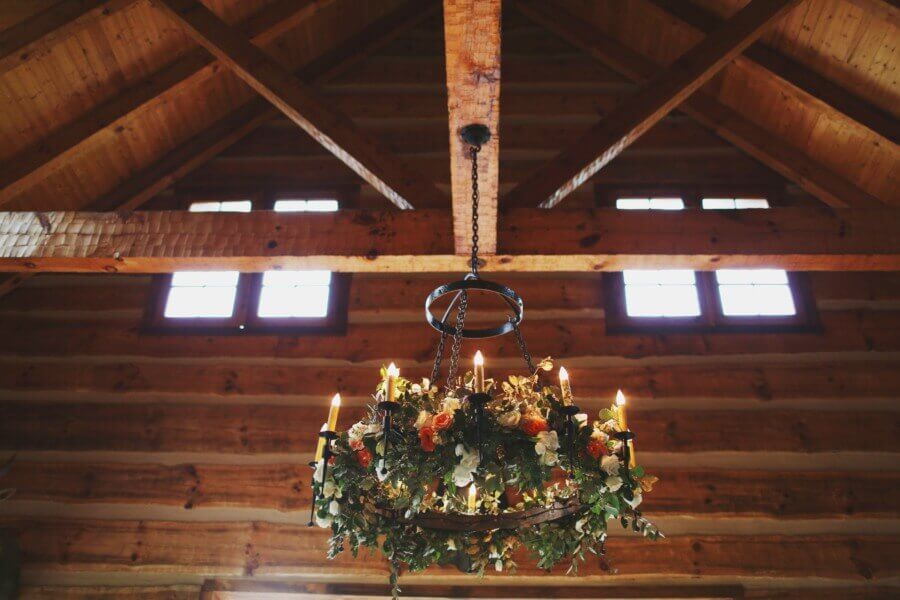 Inside the stable, an iron chandelier is festooned with flowers and greenery. Inside the stable, an iron chandelier is festooned with flowers and greenery.