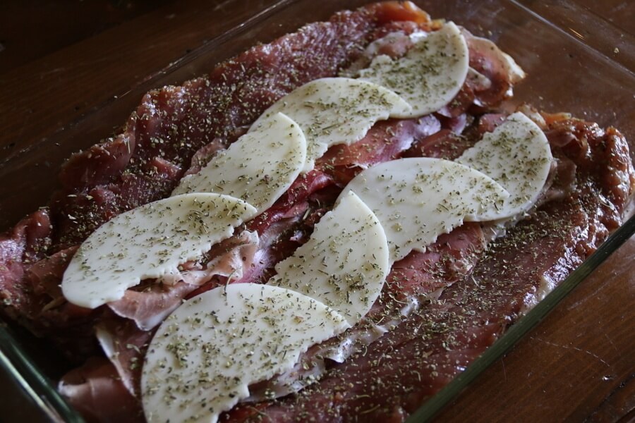 Layer the cured meat and provolone cheese and then sprinkle with Italian seasoning.