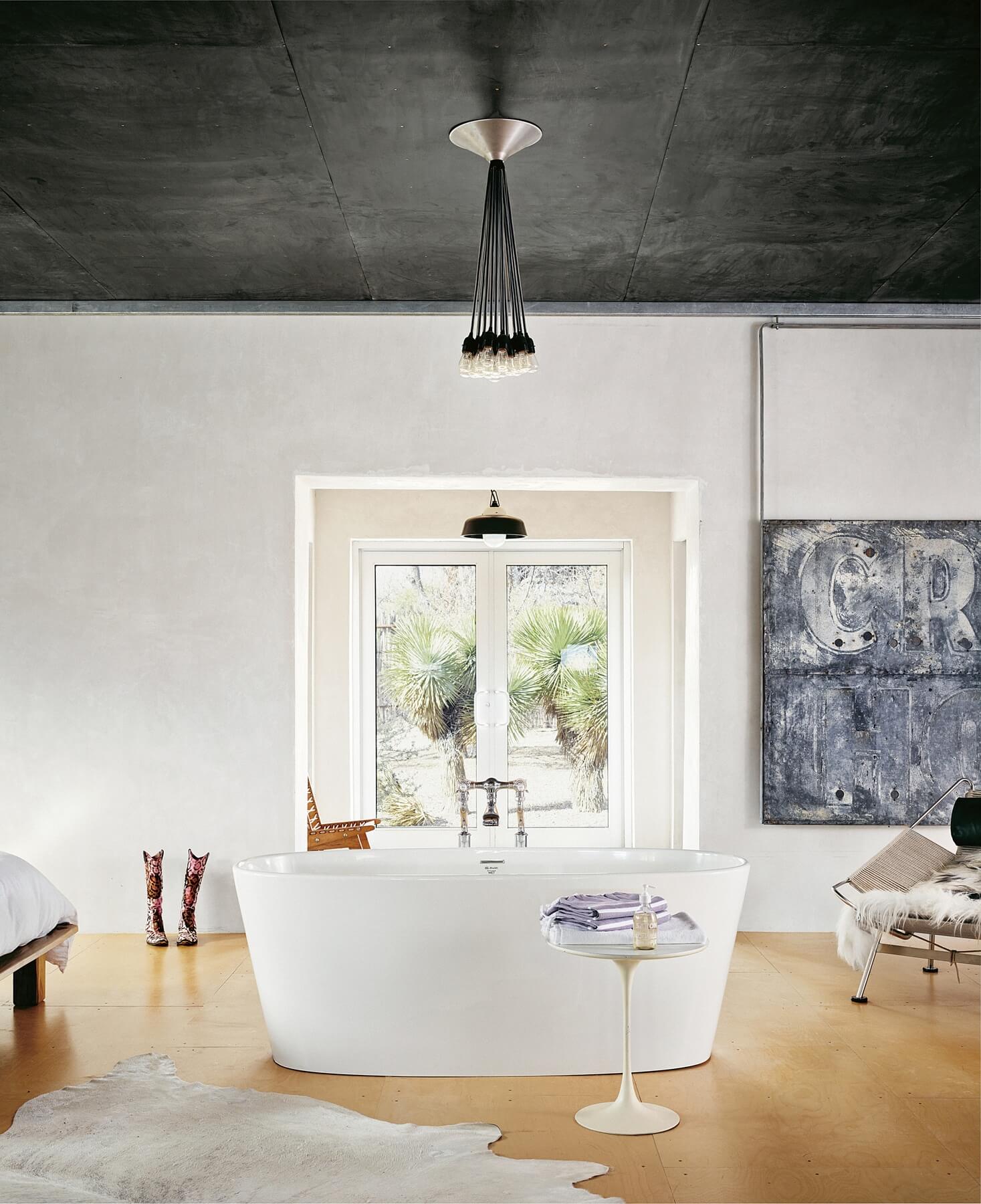A beautiful standalone bathtub doubles as a striking work of art in the middle of the bedroom with views of the spiky garden beyond. A beautiful standalone bathtub doubles as a striking work of art in the middle of the bedroom with views of the spiky garden beyond.